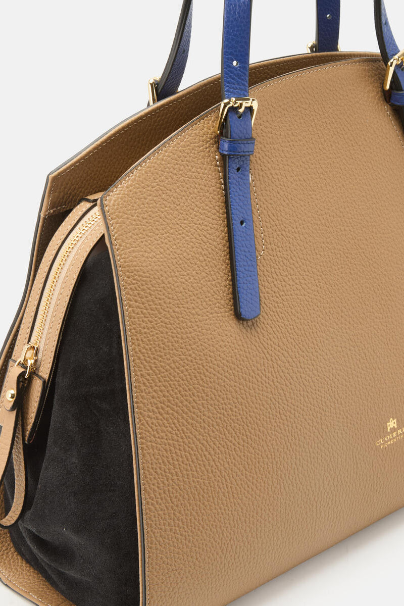 Close-up of a brown tote bag with blue detailing on a plain background.