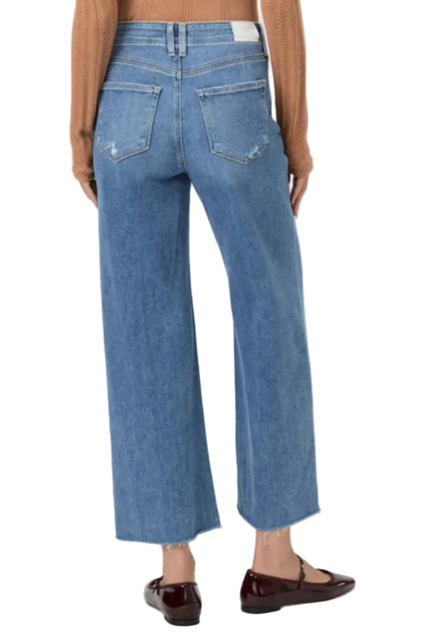 Blue jeans worn by a person on a white background.