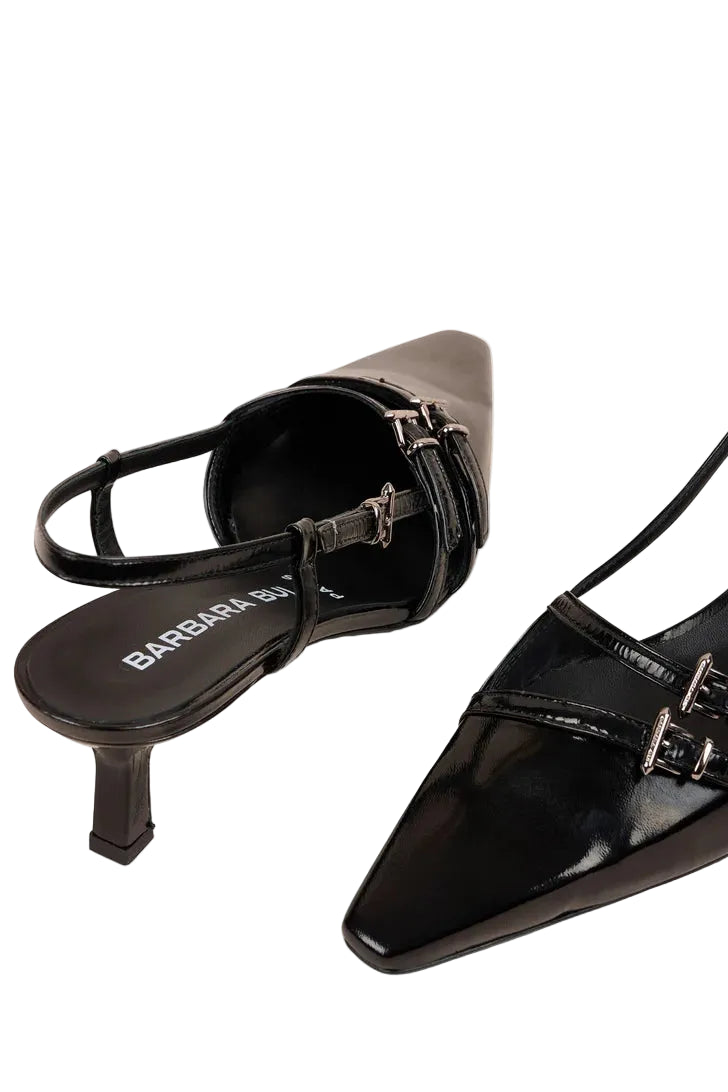 Black high-heeled shoes with a brand name on a white background.