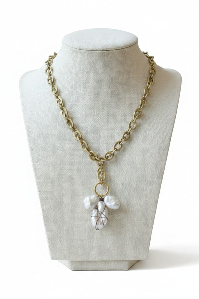 Necklace with a pearl pendant on a mannequin bust against a white background.