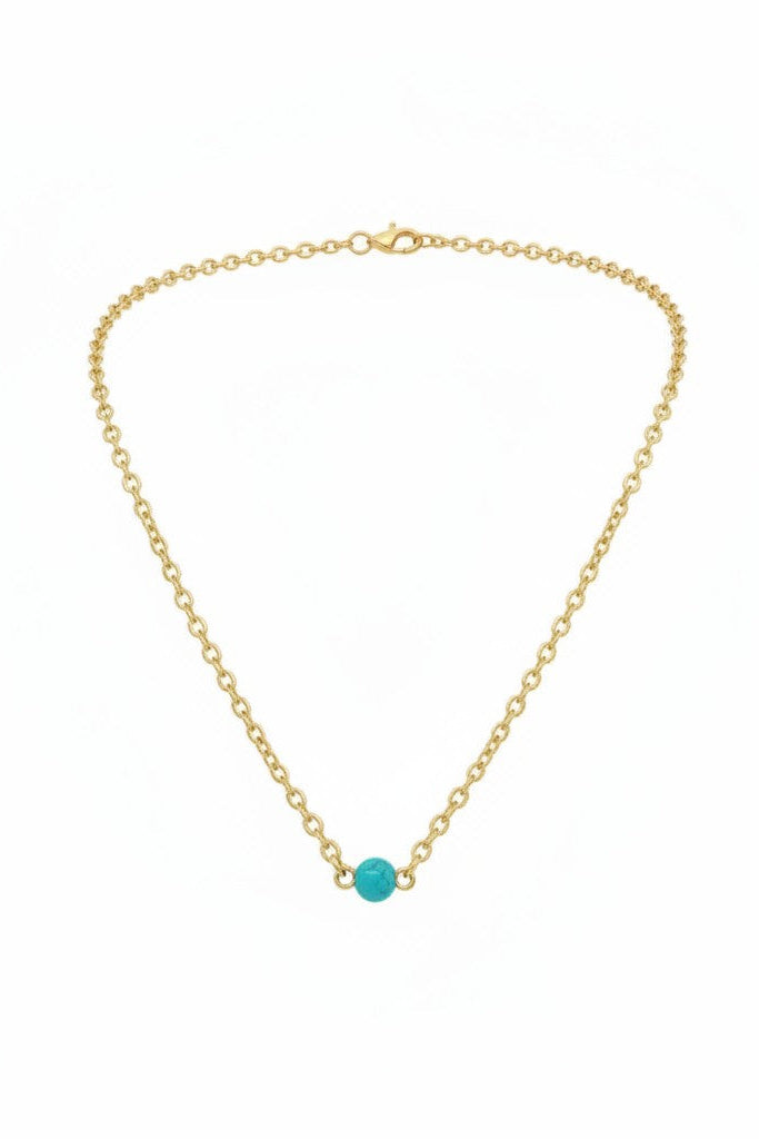 Gold chain necklace with turquoise pearl pendant on a white background.