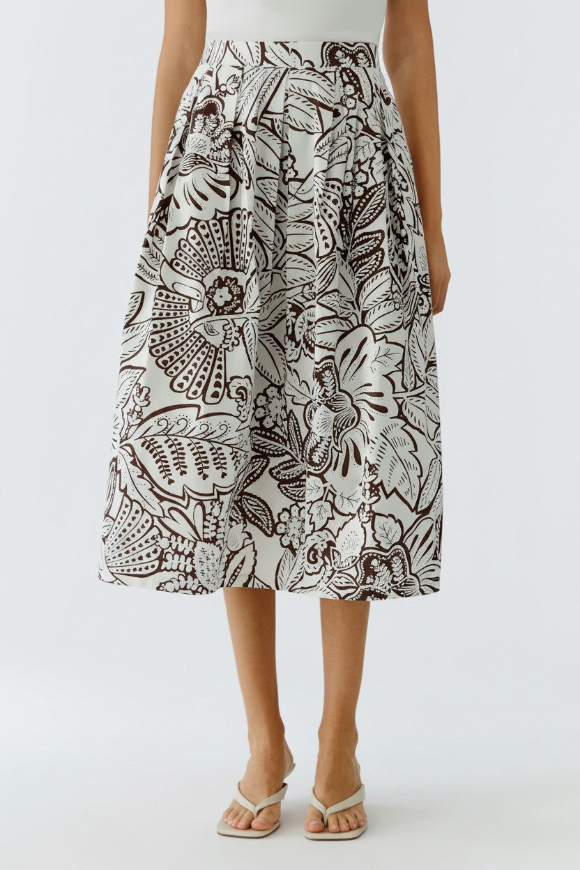 Woman wearing a brown and white patterned skirt on a white background.