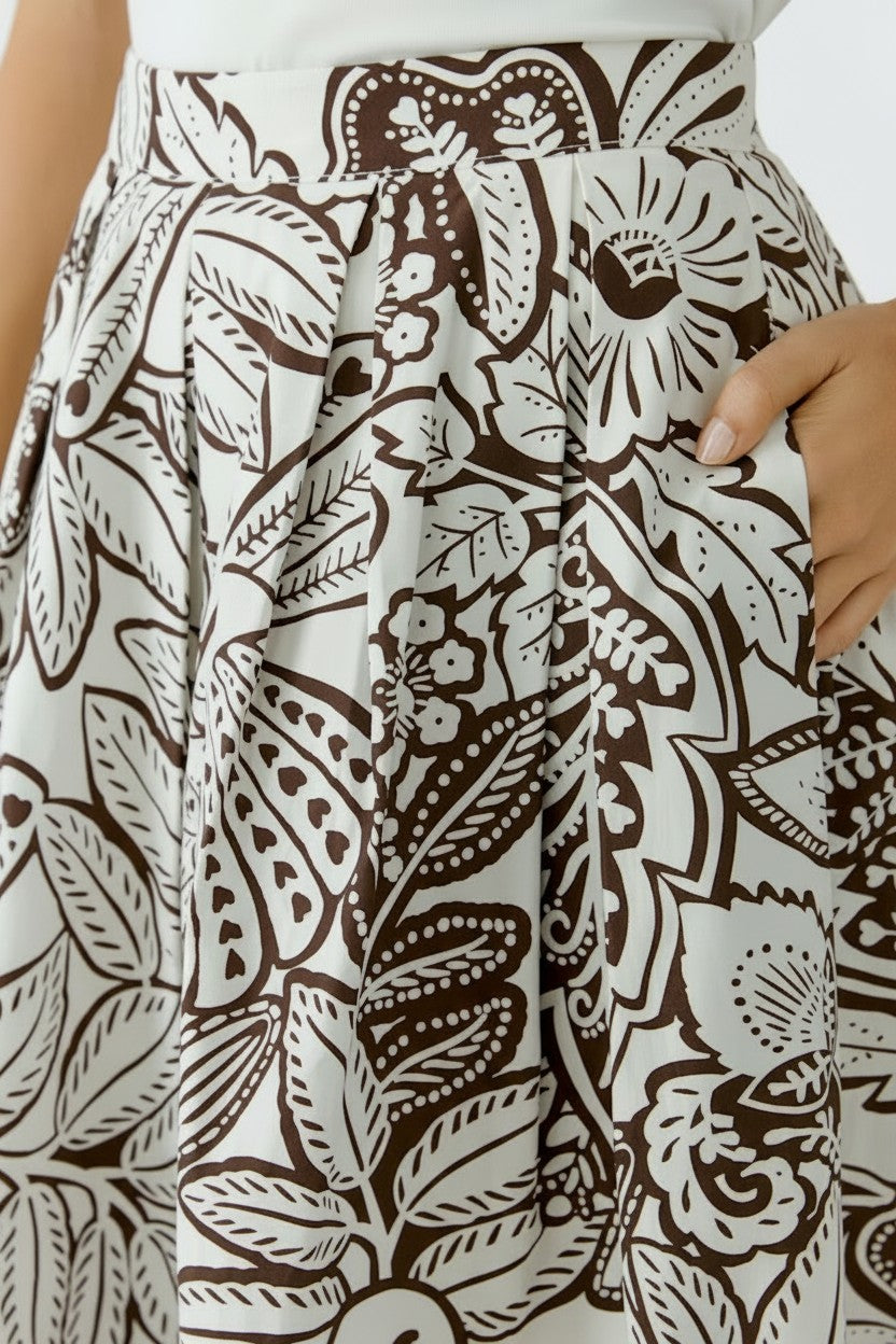 Close-up of skirt with brown and white floral pattern.