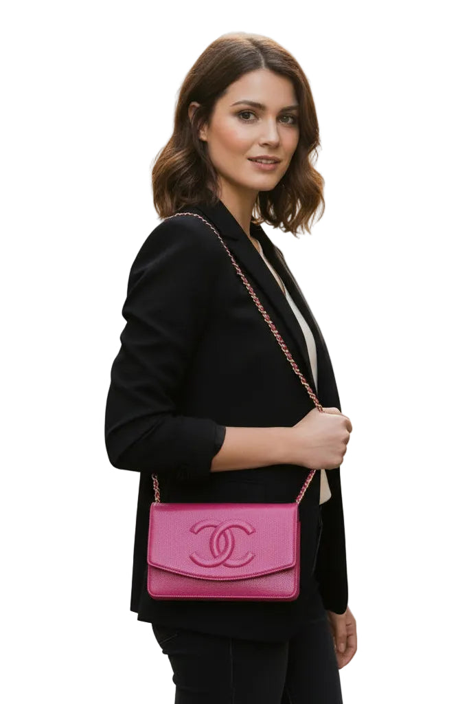 Woman holding a pink Chanel handbag against a white.