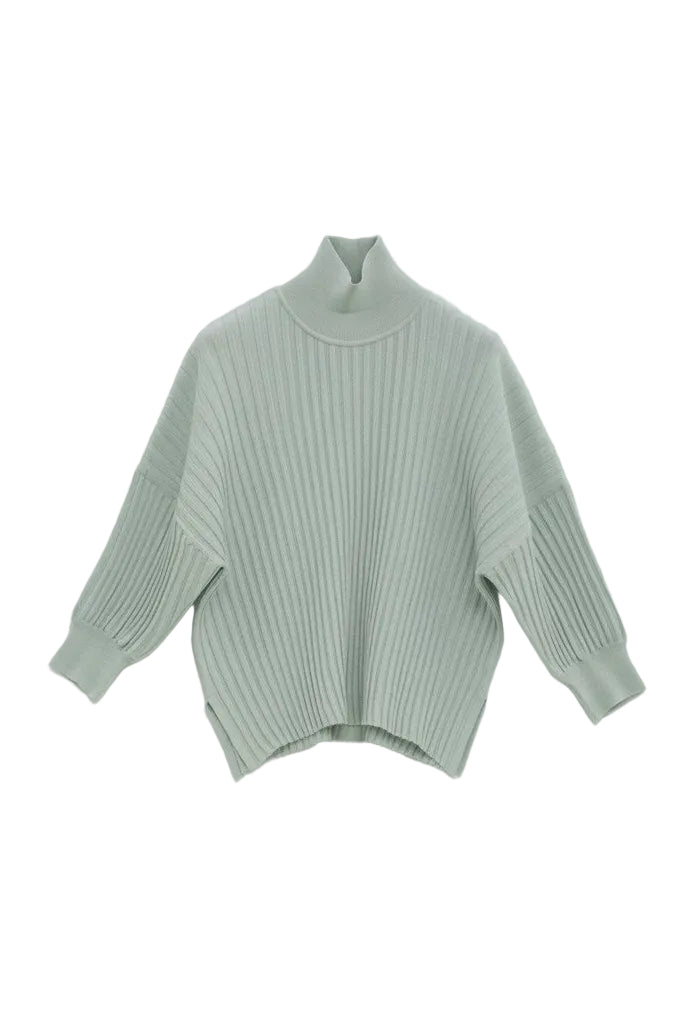 Green ribbed sweater on a light gray background