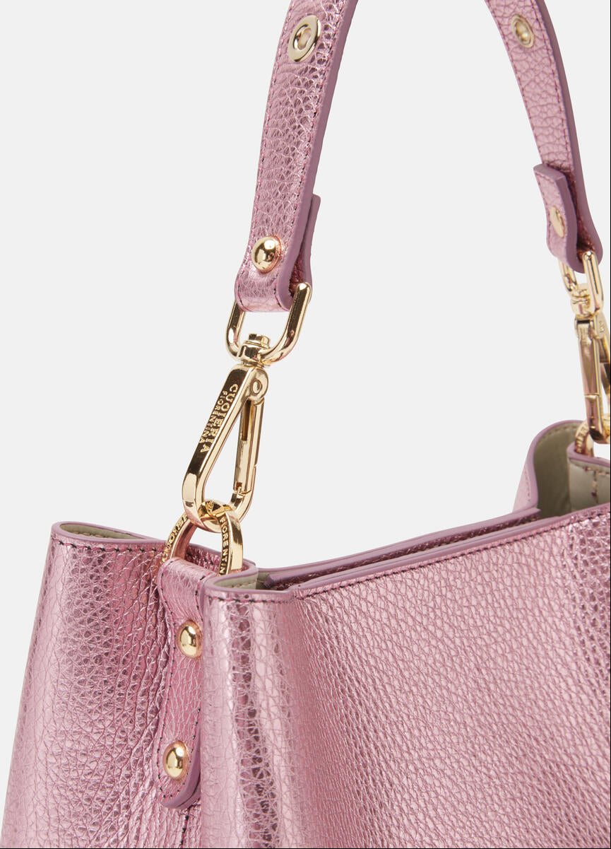 Close-up of a pink handbag with gold hardware on a white background.