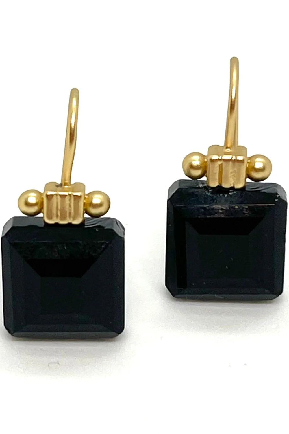 Pair of black square earrings with gold hooks on a white background