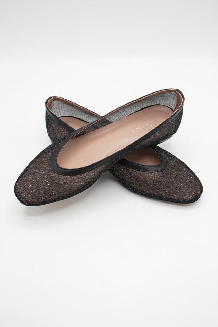 Pair of black mesh flats on a light background.