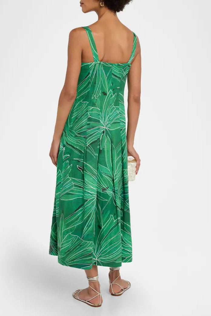 Woman wearing a green leaf-patterned dress on a white background