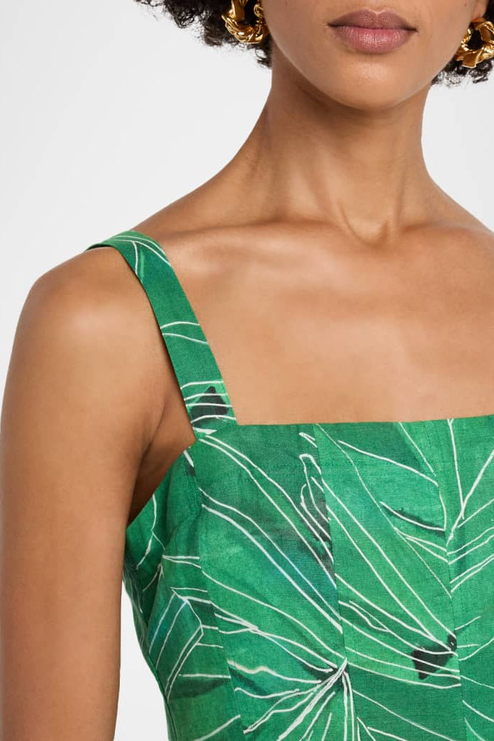 Green dress with leaf pattern worn by a person on a white background