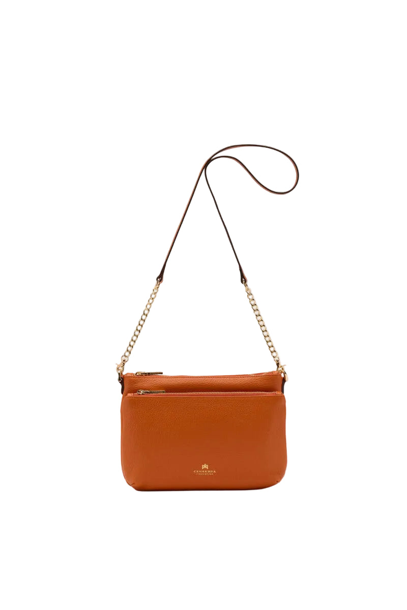 Orange leather handbag with a chain strap on a white background.