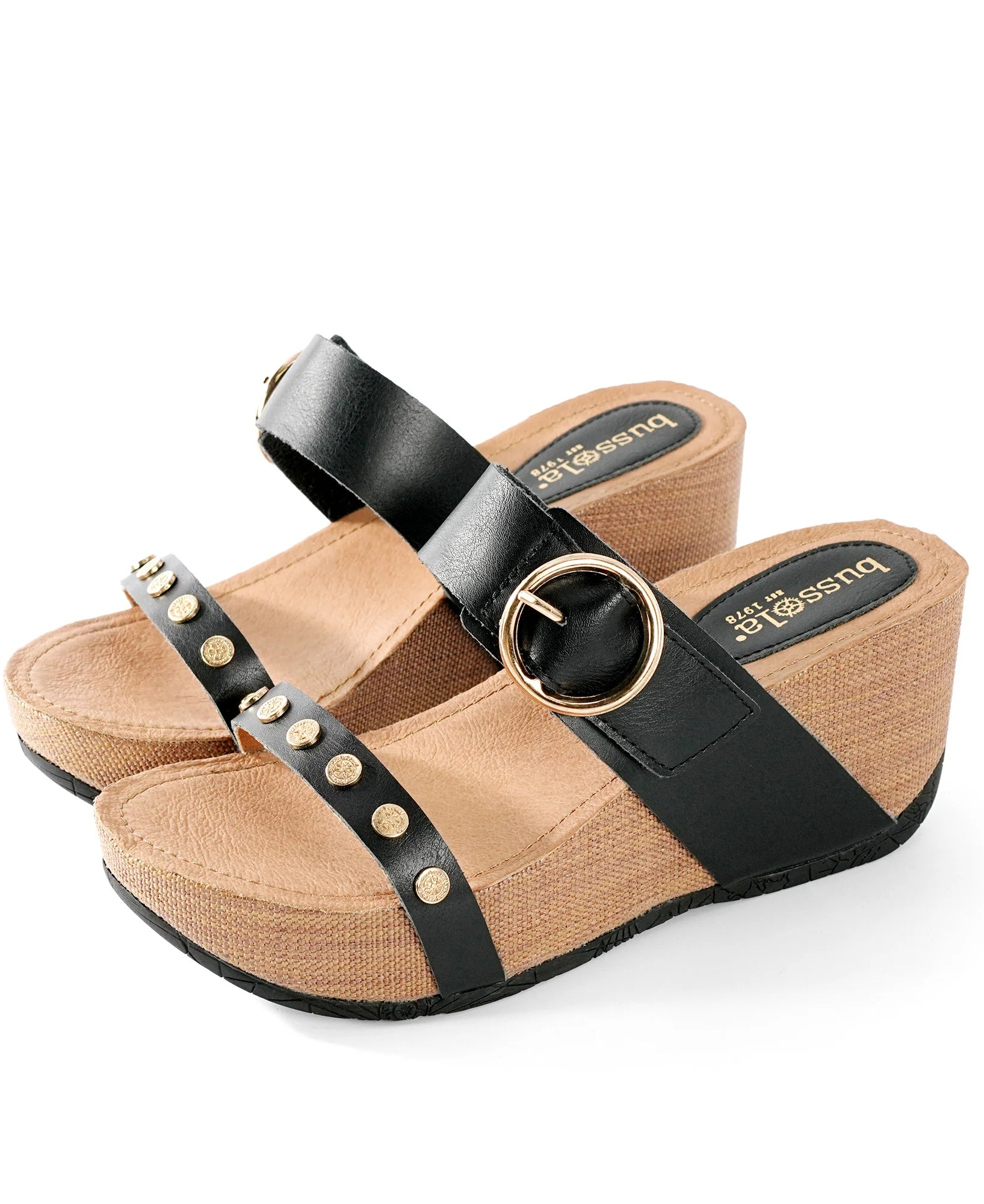 Tan wedge sandal with black strap and gold accents on a white background.