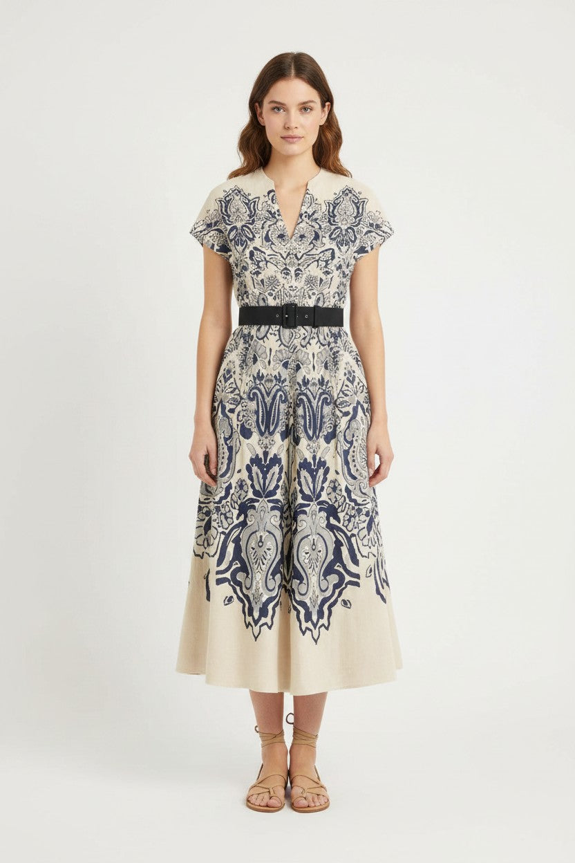 Woman wearing a patterned dress on a white background.