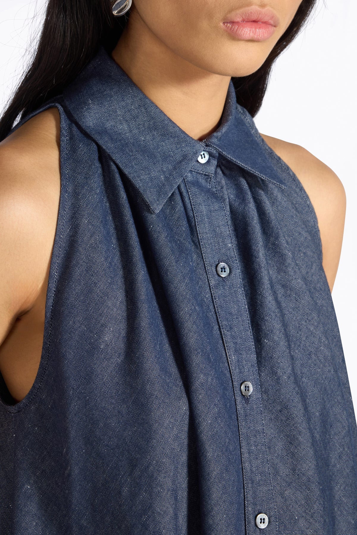 Close up of blue sleeveless dress worn by a womanon a white background