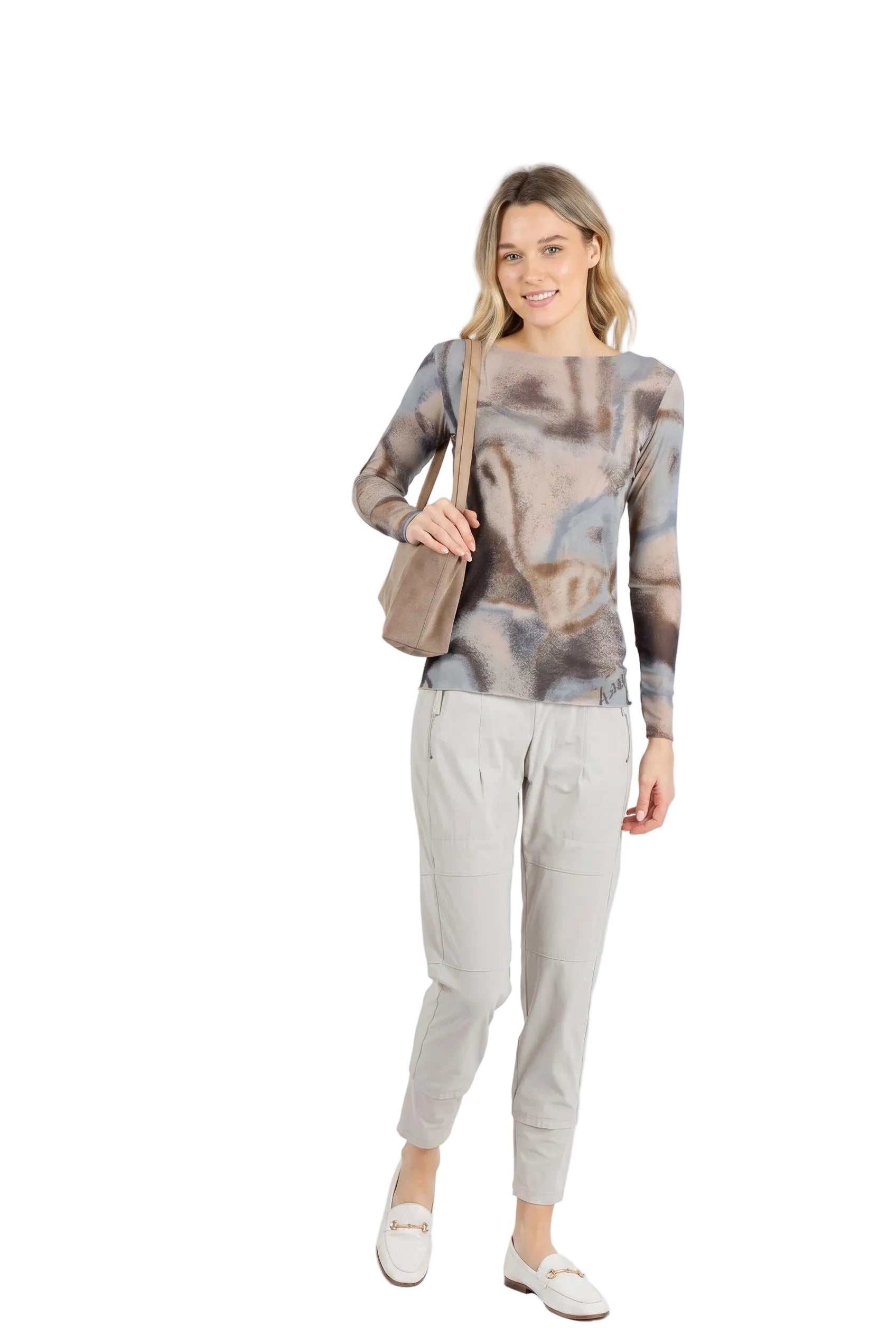 Woman wearing a patterned top and light pants with a beige bag on a white background.