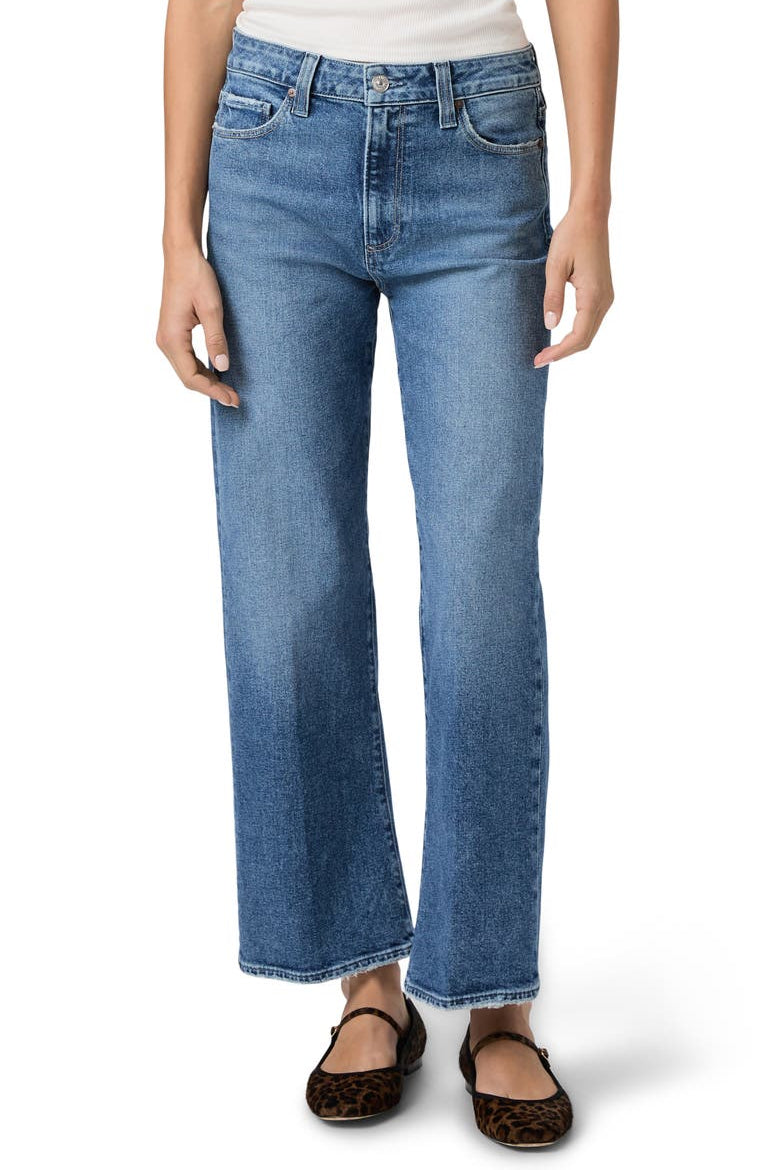 Woman wearing blue jeans on a white background.