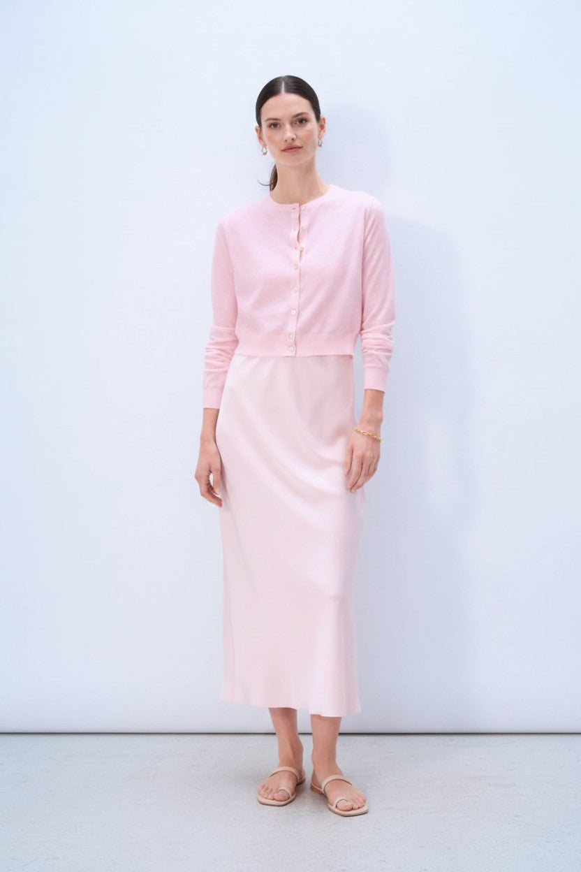 Woman wearing a pink outfit against a white background.