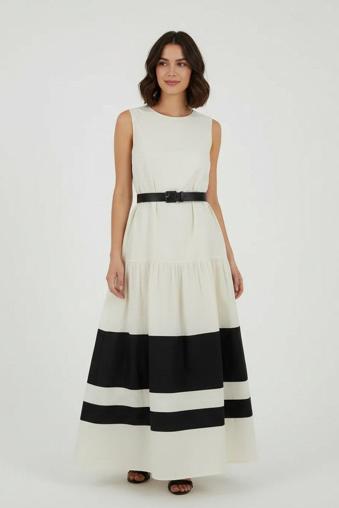 Woman wearing a off-white dress with black stripes on a plain background.