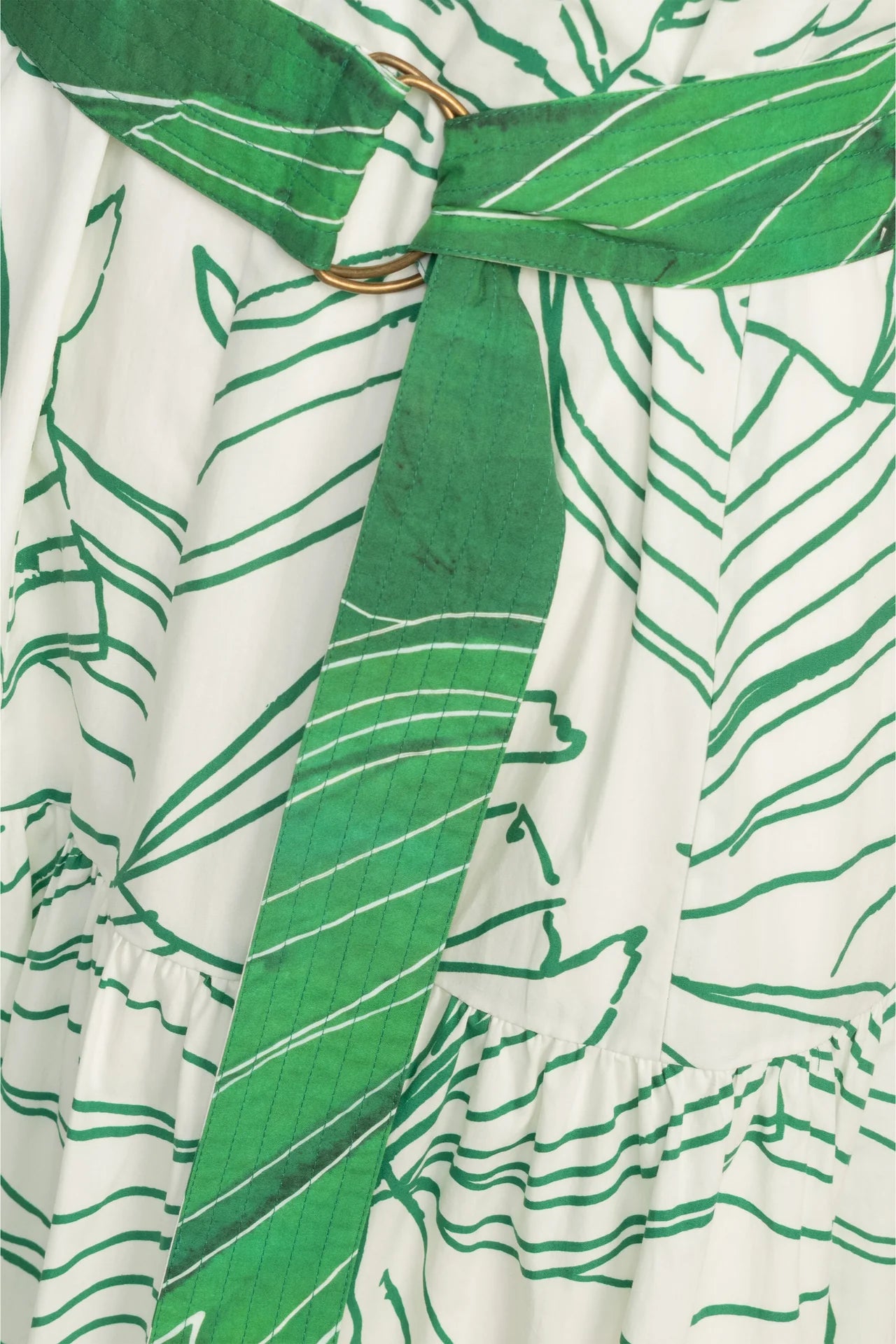 Close-up of a green and white patterned dress with a tie.