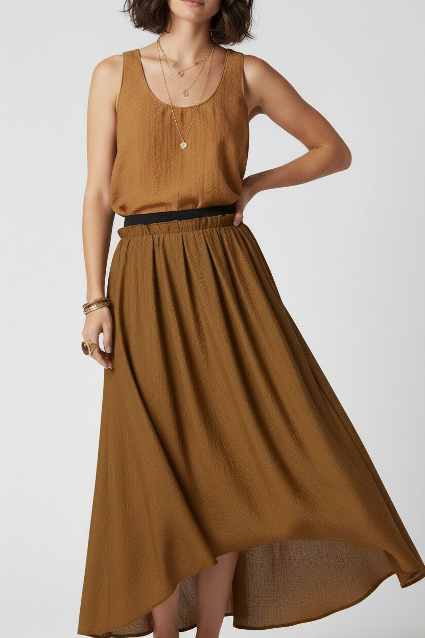 Close-up of a woman wearing a brown sleeveless two piece outfit on a white background.