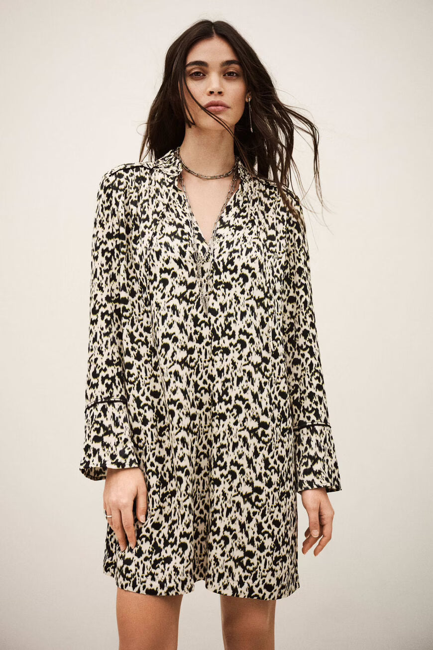 Woman wearing a leopard print dress against a plain background.