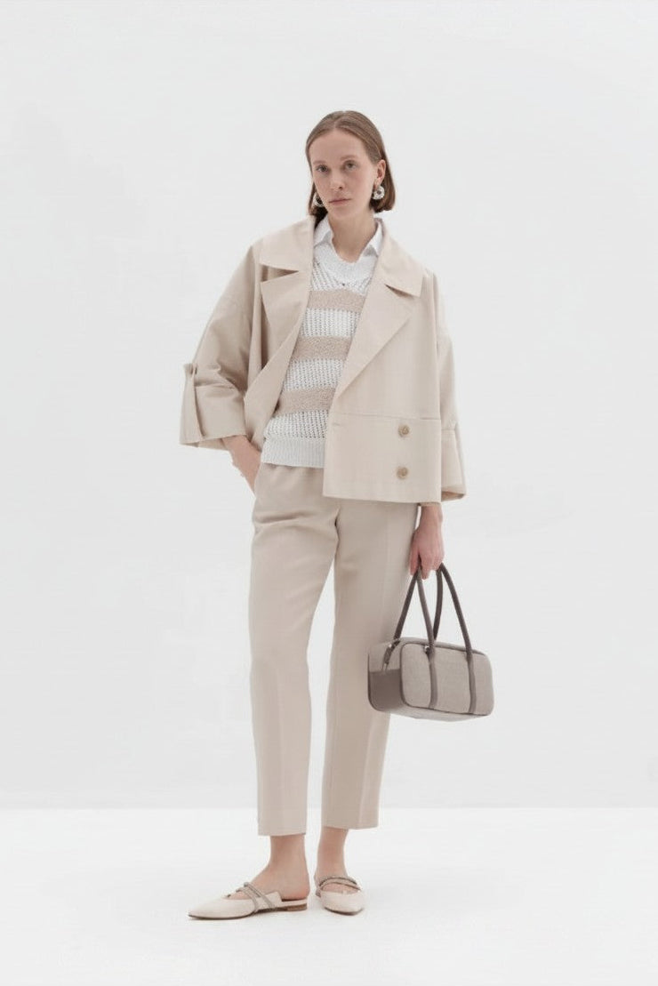 Woman wearing a beige outfit with a white background.