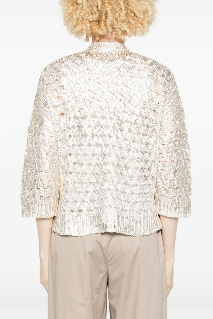 The back of a woman wearing a gold cardigan on a white background.