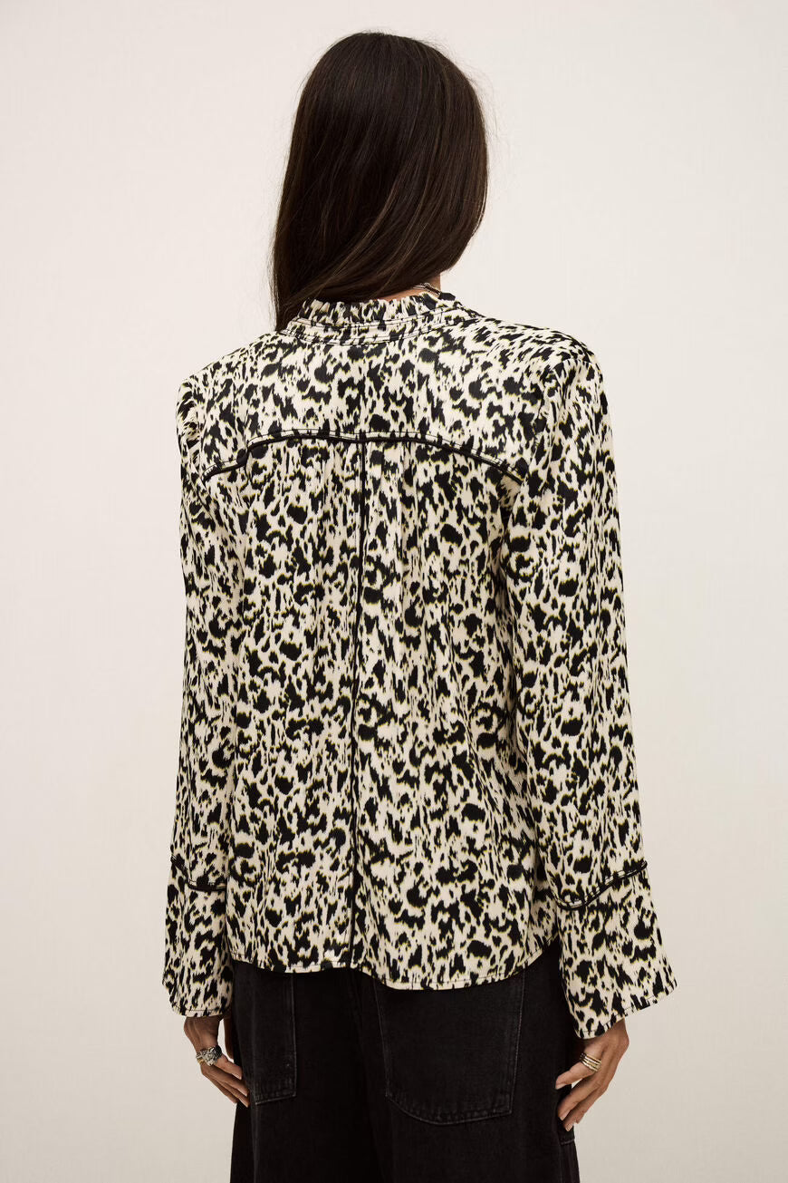 Person wearing a leopard print jacket on a plain background.