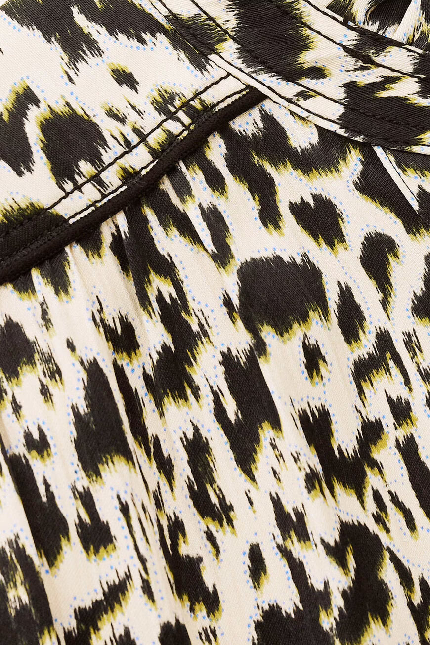 Close-up of a fabric with a leopard print pattern on a beige background.