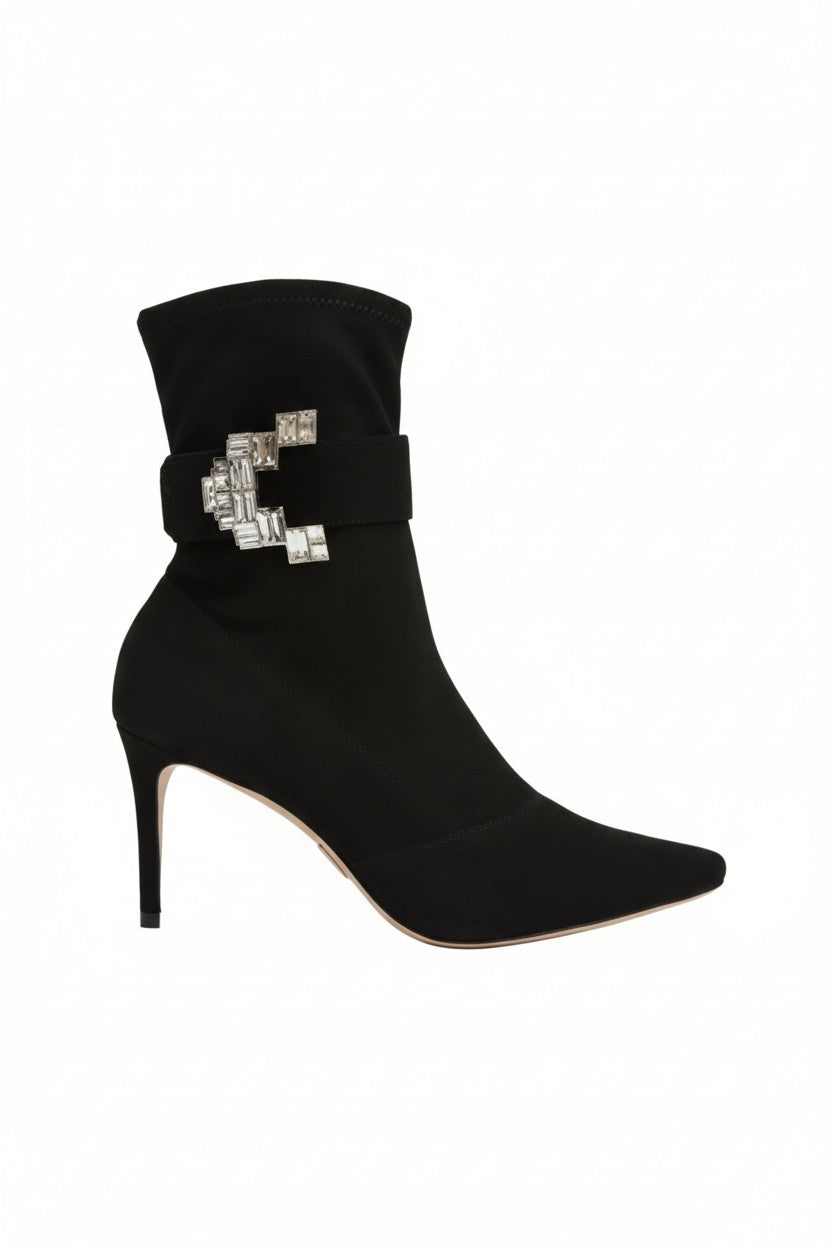 Black ankle boot with a decorative buckle on a white background.