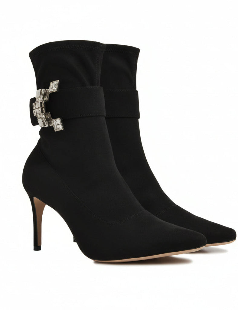 Black ankle boots with a decorative buckle on a white background.