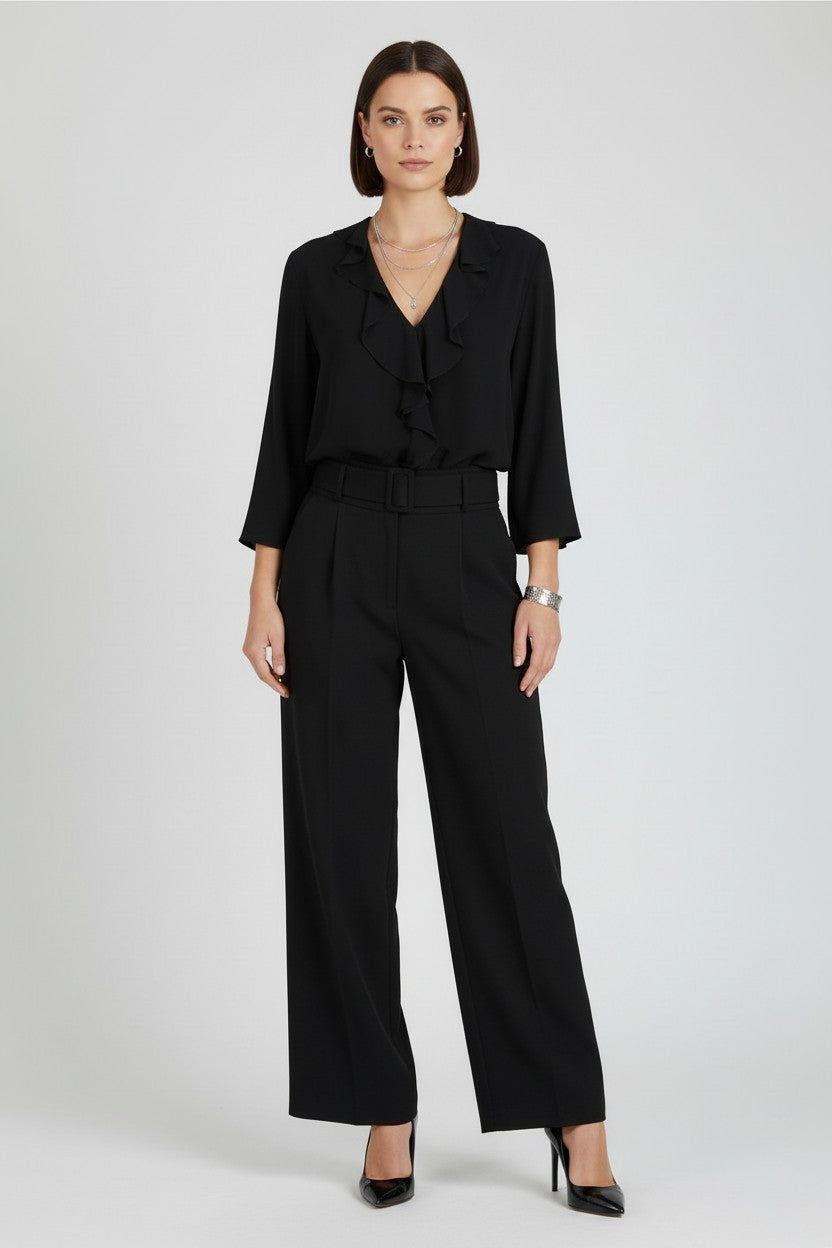 Woman wearing a black outfit with a plain background.