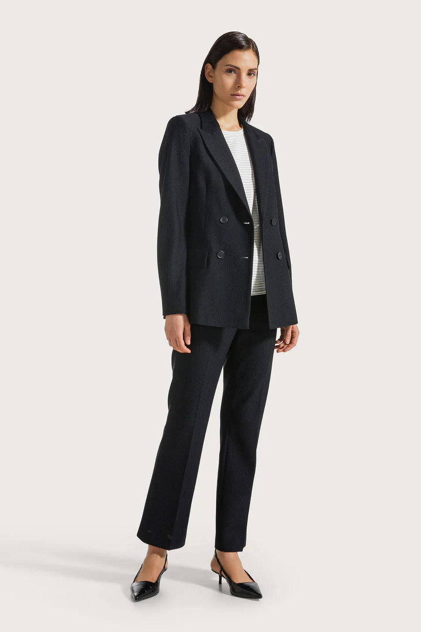 Woman wearing a black suit on a white background.