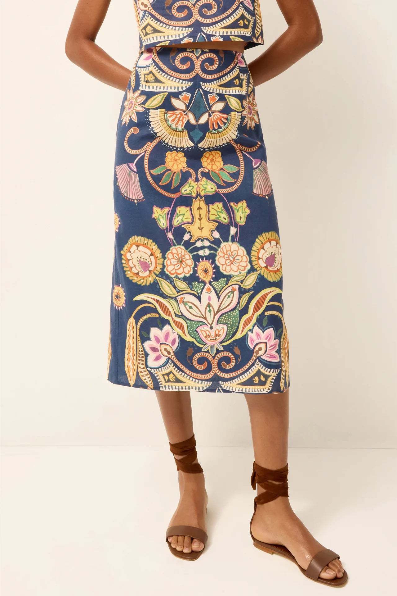 Person wearing a colorful patterned skirt on a white background.