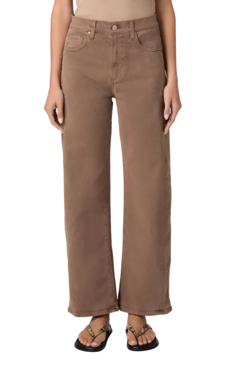 Brown wide-leg jeans worn by a person on a white background.