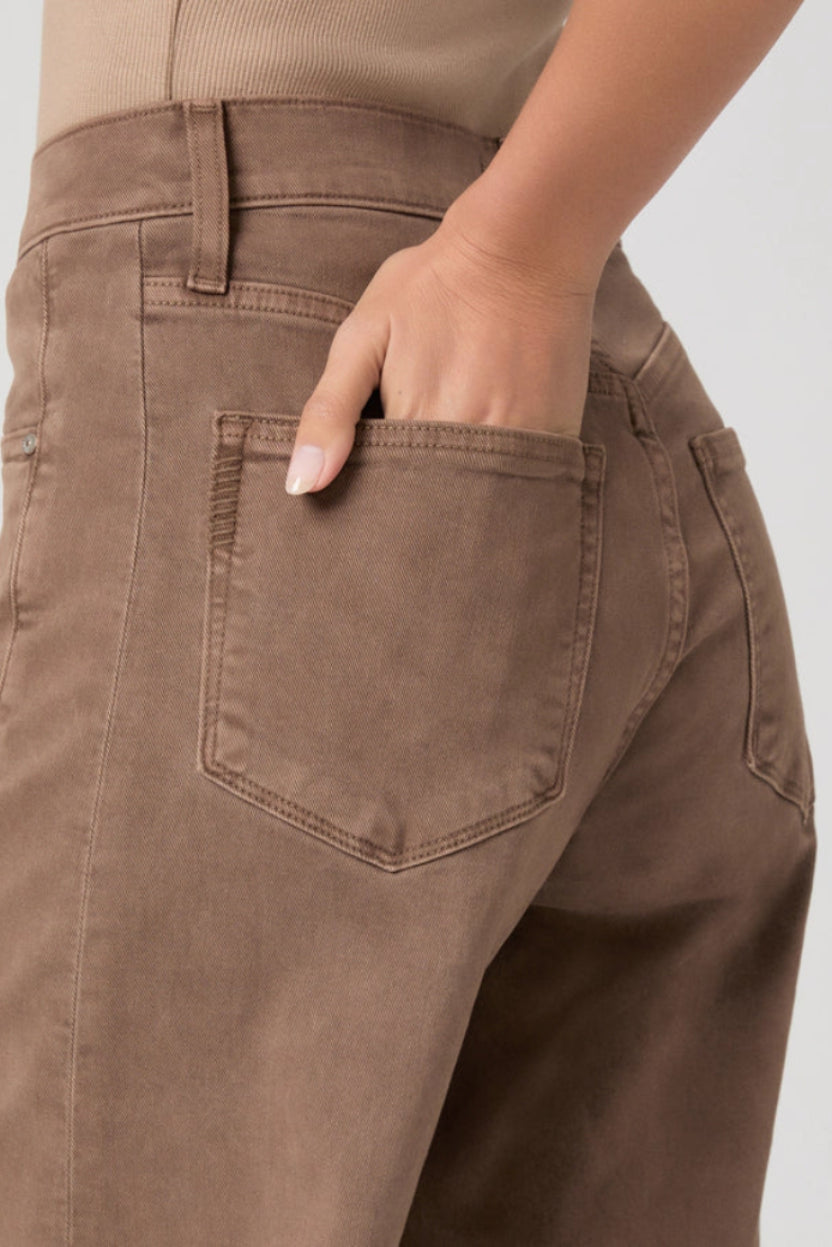 Brown jeans with a pocket on a plain background.