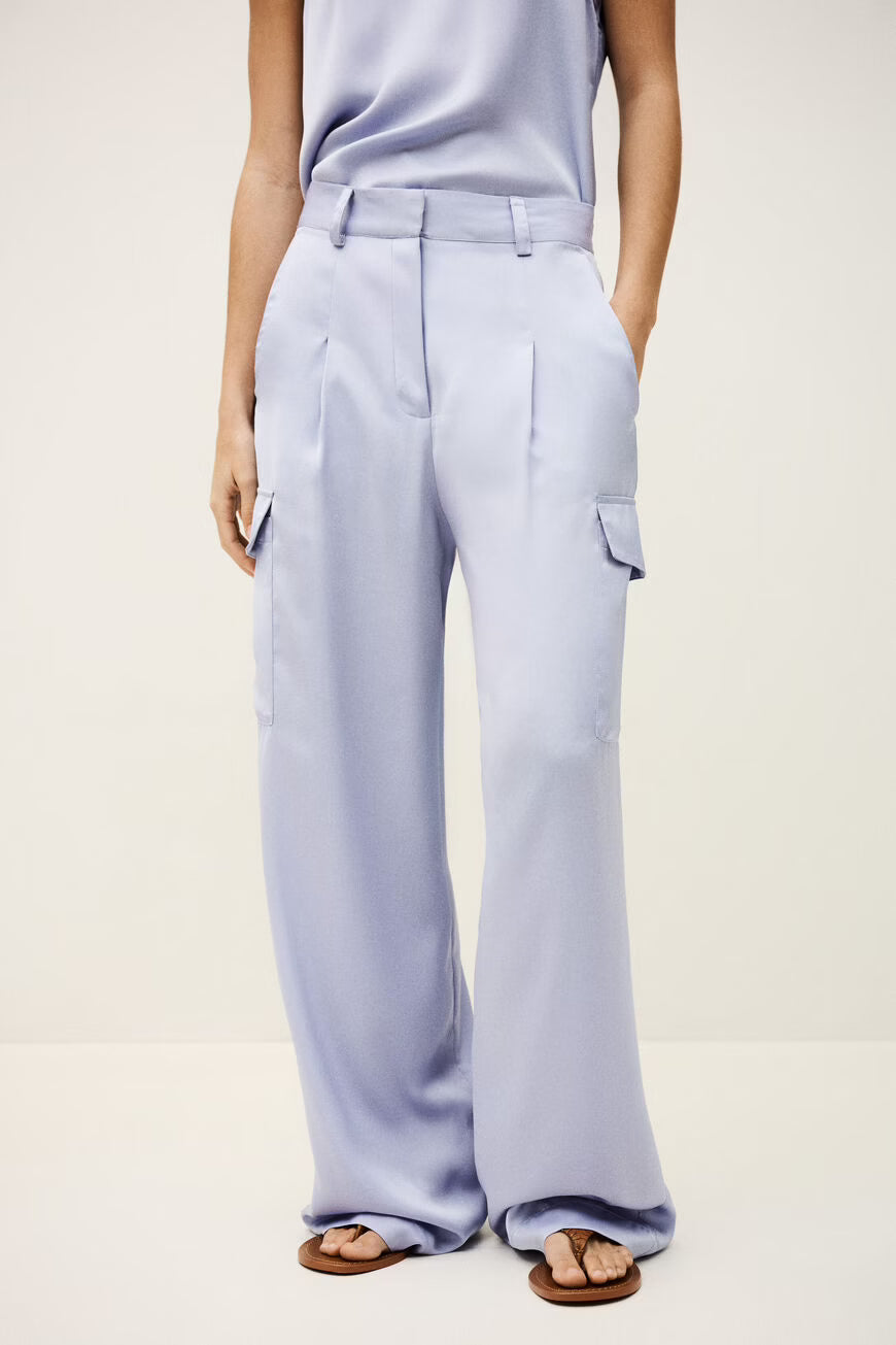 Woman wearing light purple pants worn by a person on a white background.
