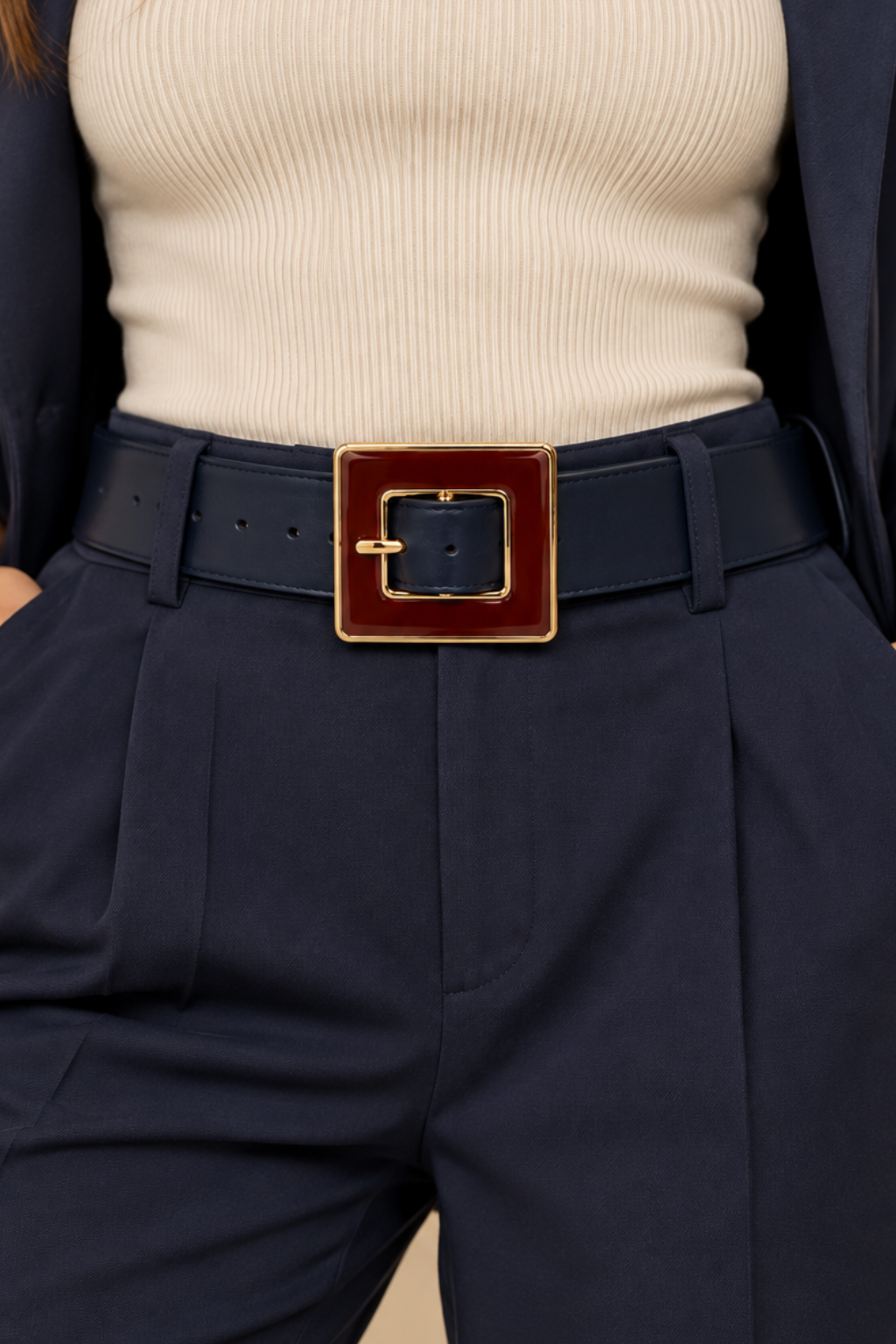 Gavazzeni Angelica navy blue leather belt with an oversized burgundy and gold-tone rectangular buckle, styled through the belt loops of navy tailored trousers with a matching blazer and ivory top.