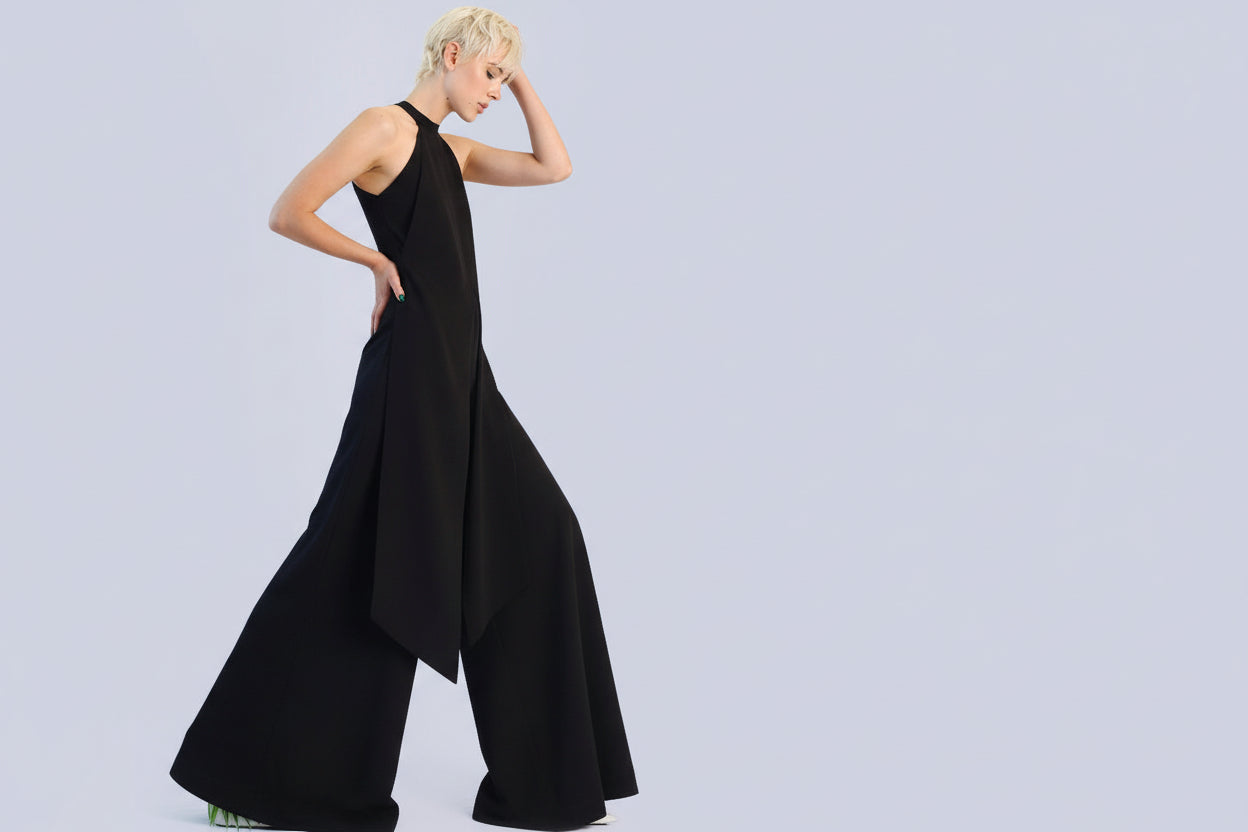 Woman wearing a black dress with a flowing skirt on a light gray background