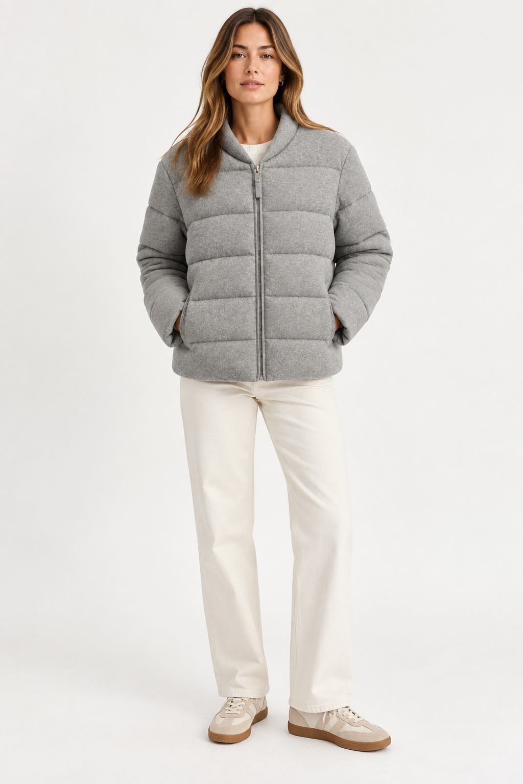 Model wearing the gray Allude cashmere quilted jacket with cream pants, shown from the front.