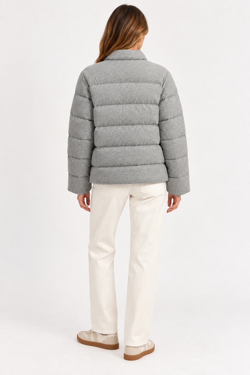 Model wearing the gray Allude cashmere quilted jacket with cream pants, shown from the back.