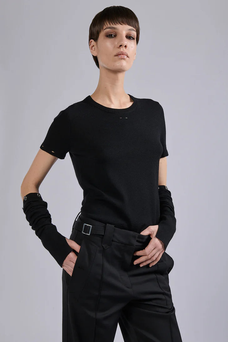 Person wearing a black outfit with detatchable long sleeves on a gray background.