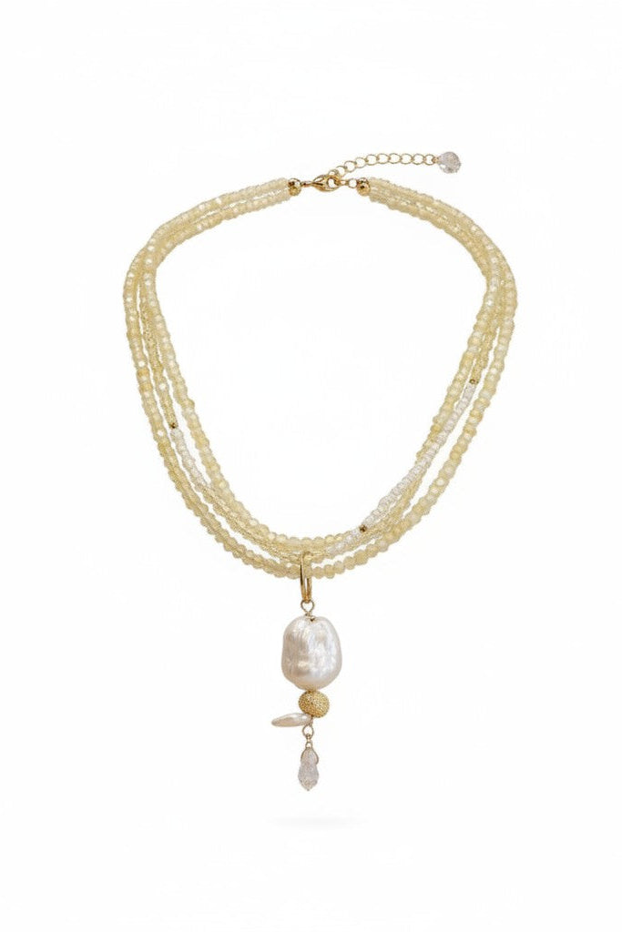 Layered necklace with a large central pearl on a white background.