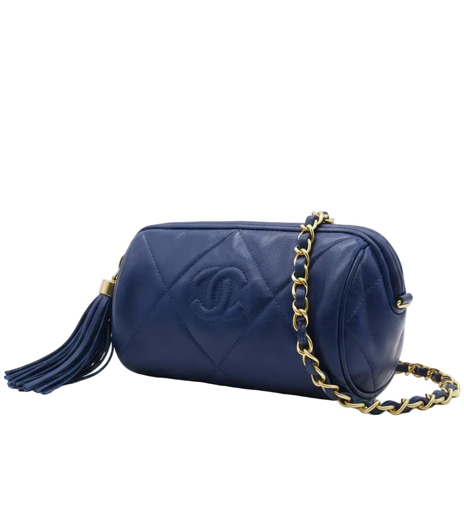 Blue handbag with gold chain strap on a white background.