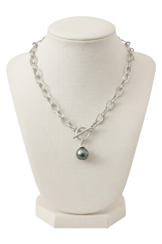 Silver chain necklace with blue/green colored pearl on a display with a white background.