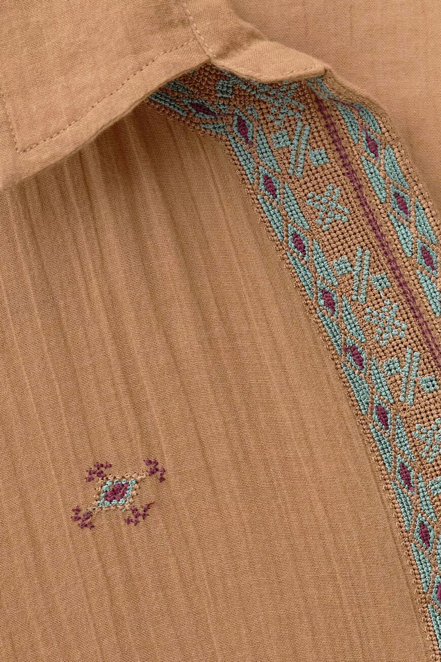 Close-up of a brown top with a boho pattern.