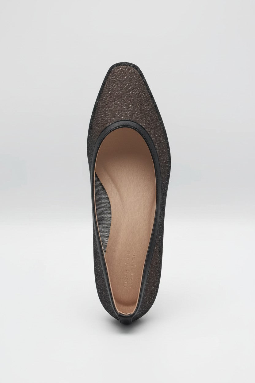 Black pointed-toe flat on a light background.