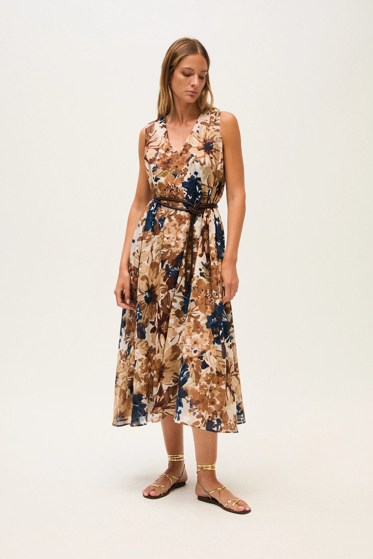 Woman wearing a floral dress on a white background.