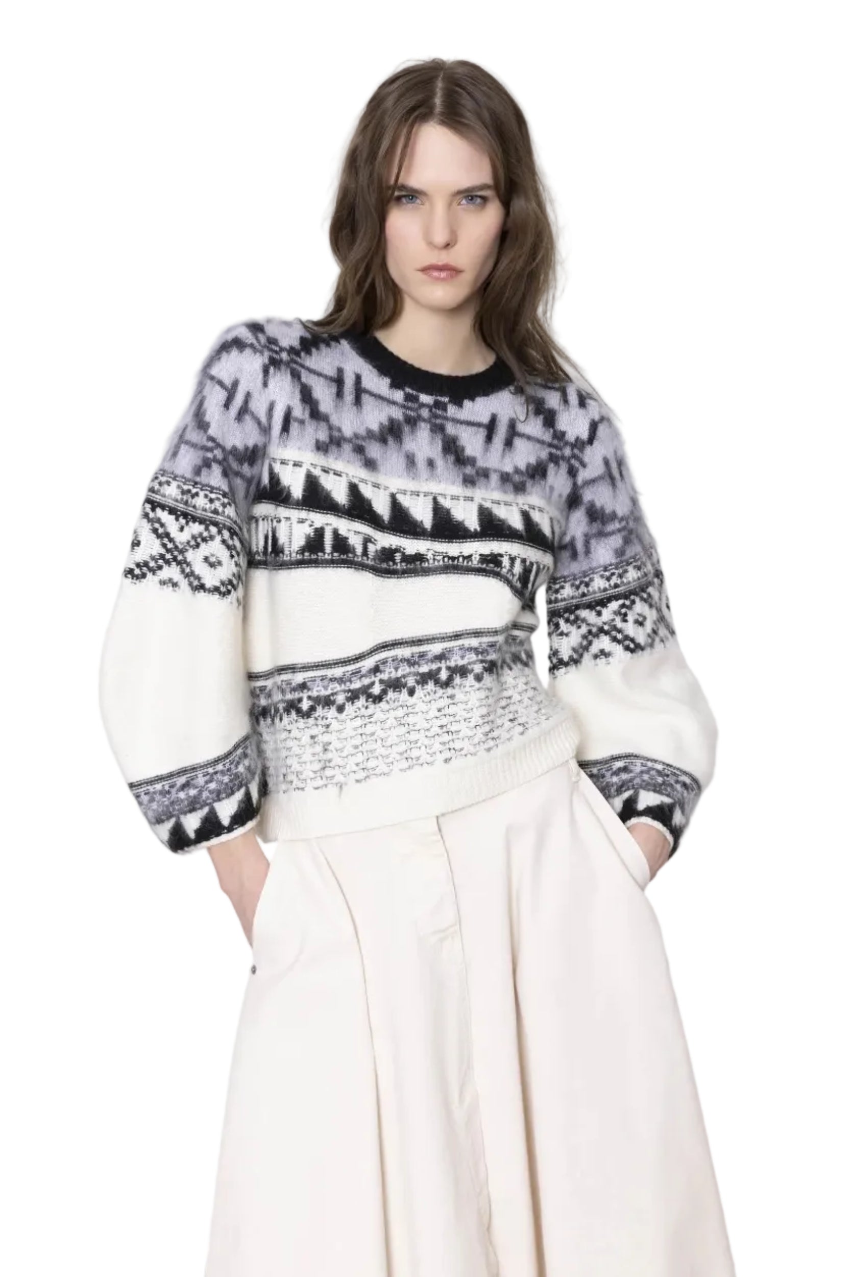 Woman wearing a patterned sweater and white pants against a white background.