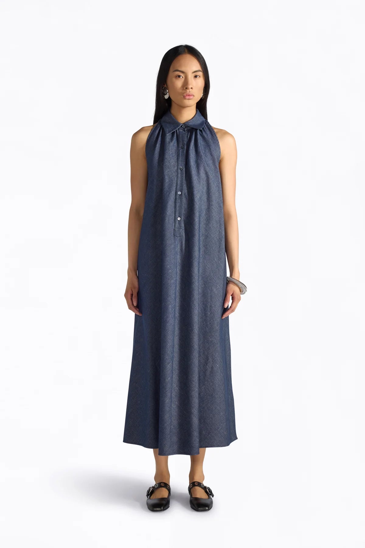 Woman wearing a long blue dress on a white background.